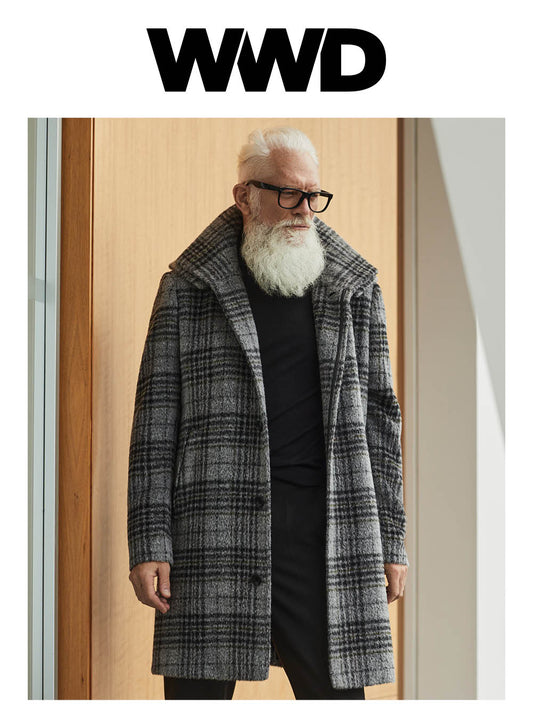 Image features the WWD logo and an image of a male model wearing the Sentaler Technical Suri Alpaca Double Collar Overcoat featured in Technical Bouclé Suri Alpaca and available in Grey Plaid Grey. Seen from front open.