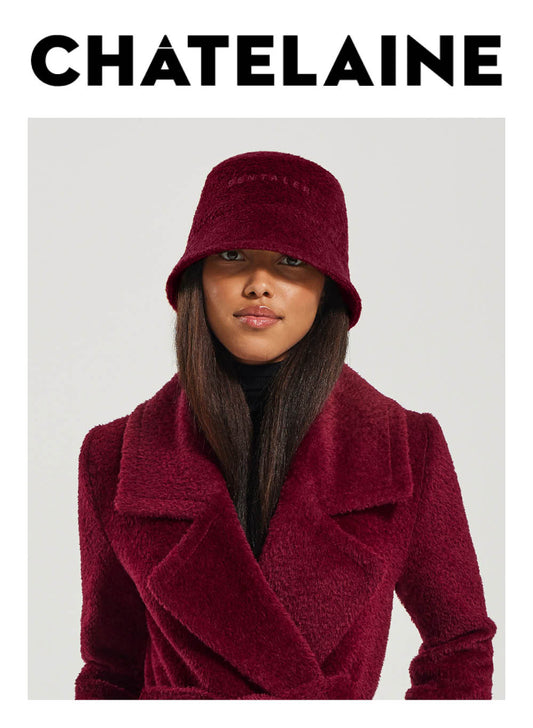 Image features the Chatelaine logo and an image of a female model wearing the Sentaler Bouclé Alpaca Bucket Hat featured in Bouclé Alpaca and available in Garnet Red. Seen from front close up.