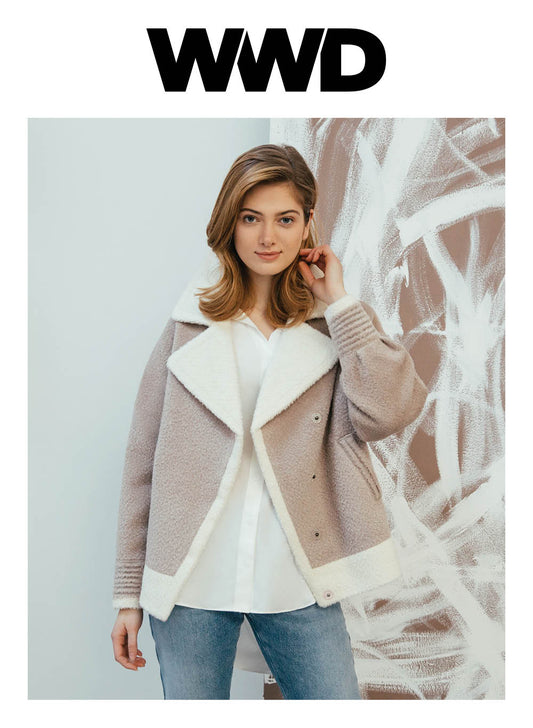 Image features the WWD logo and an image of a female model wearing the Sentaler Bouclé Alpaca Dropped Shoulder Boyfriend Jacket featured in Bouclé Alpaca and available in Sand Neutral. Seen from front above the knees open.