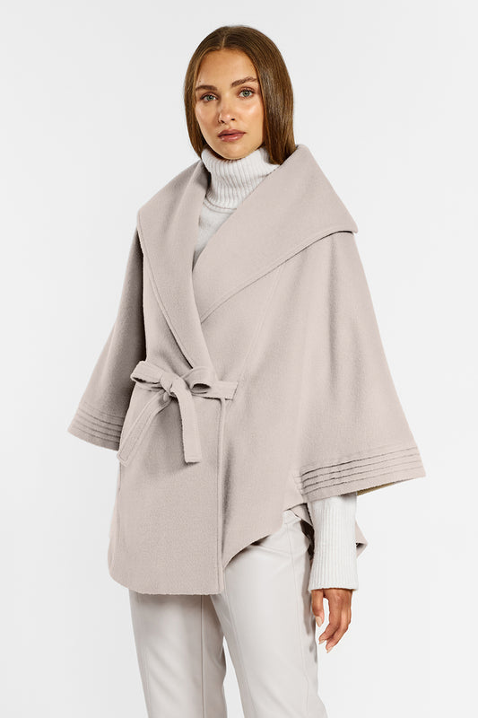 Sentaler Cape with Shawl Collar and Belt crafted in Baby Alpaca wool and in Bleeker Beige. Seen from side above the knees on female model.