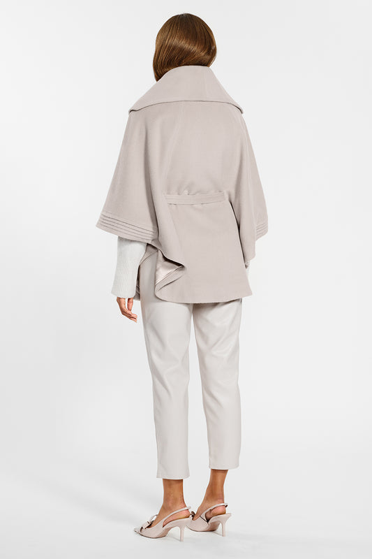 Sentaler Cape with Shawl Collar and Belt crafted in Baby Alpaca wool and in Bleeker Beige. Seen from back on female model.Sentaler Cape with Shawl Collar and Belt crafted in Baby Alpaca wool and in Bleeker Beige. Seen from back on female model.
