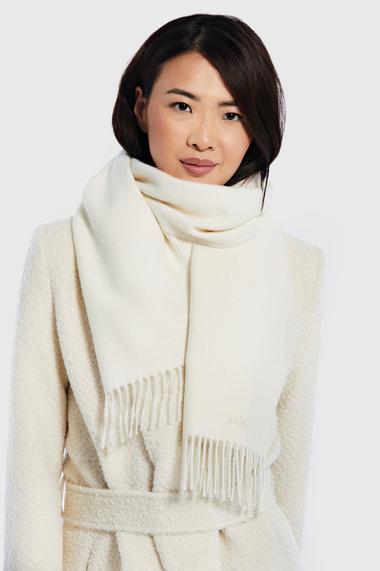 Sentaler Baby Alpaca Classic Scarf featured in Baby Alpaca and available in Ivory White. Seen from front close up on female model.