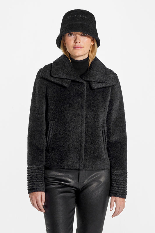 Sentaler Bouclé Alpaca Bucket Hat and Bouclé Alpaca Moto Jacket with Signature Double Collar featured in Bouclé Alpaca and available in Black. Seen from front above the knees on model.
