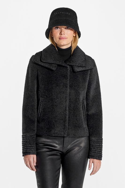 Sentaler Bouclé Alpaca Moto Jacket with Signature Double Collar and Bouclé Alpaca Bucket Hat featured in Bouclé Alpaca and available in Black. Seen from front above the knees on model.