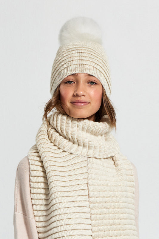  Sentaler Kids (6-14 Years) Ribbed Hat with Oversized Fur Pompon featured in Baby Alpaca and available in Ivory. Seen from front.
