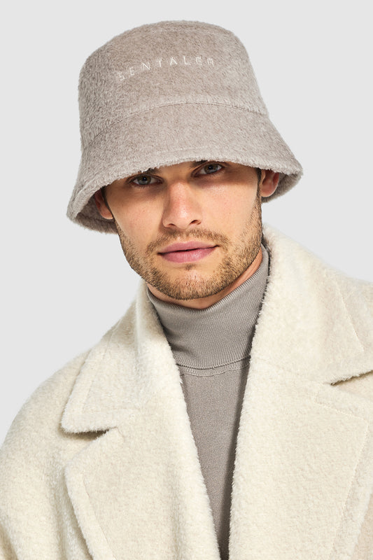 Sentaler Mens Bouclé Alpaca Bucket Hat featured in Bouclé Alpaca and available in Sand. Seen from front close up on model.